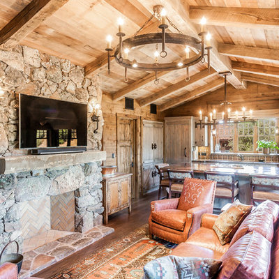 Family room - mid-sized rustic open concept medium tone wood floor family room idea in San Francisco with a standard fireplace, a stone fireplace and a wall-mounted tv