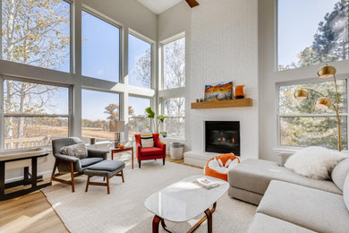Large trendy open concept laminate floor, beige floor and vaulted ceiling family room photo in Denver with white walls, a standard fireplace and a brick fireplace