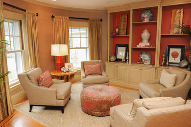 Imagen de sala de estar con biblioteca abierta tradicional de tamaño medio con paredes beige, suelo de madera clara y suelo naranja