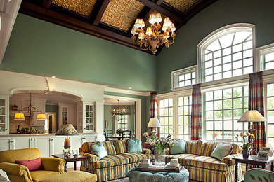 Offenes Klassisches Wohnzimmer mit grüner Wandfarbe, braunem Holzboden, Kamin, gefliester Kaminumrandung, TV-Wand und braunem Boden in Philadelphia