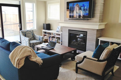 Family room - mid-sized traditional enclosed dark wood floor and brown floor family room idea in Calgary with beige walls, a standard fireplace, a tile fireplace and a wall-mounted tv