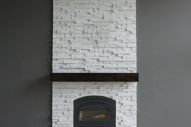 Ispirazione per un soggiorno minimalista con parquet scuro, camino classico, cornice del camino in pietra e pavimento marrone