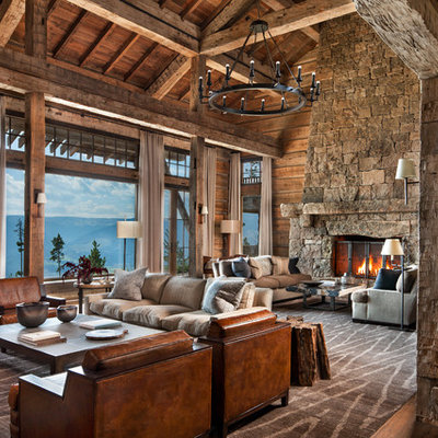 Inspiration for a huge rustic open concept medium tone wood floor and brown floor family room remodel in Other with brown walls, a standard fireplace and a stone fireplace