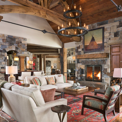 Inspiration for a rustic medium tone wood floor family room remodel in Other with a standard fireplace, a stone fireplace and a concealed tv