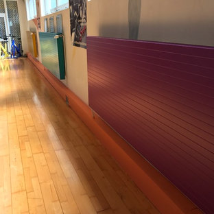 Foto di una piccola palestra multiuso mediterranea con pareti bianche, pavimento in legno massello medio e pavimento marrone