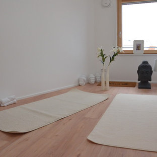 Esempio di un piccolo studio yoga etnico con pareti bianche, parquet chiaro e pavimento beige
