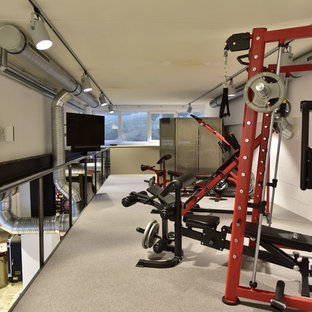 Immagine di una sala pesi industriale di medie dimensioni con pareti bianche, moquette e pavimento grigio