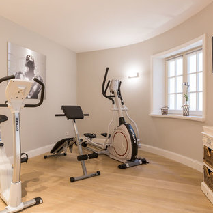 Immagine di una piccola palestra multiuso country con pareti beige, parquet chiaro e pavimento beige