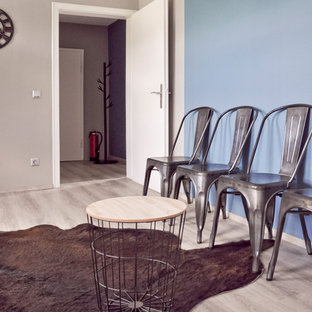 Esempio di una palestra in casa industriale di medie dimensioni con pareti grigie, pavimento in laminato, pavimento grigio e soffitto in carta da parati