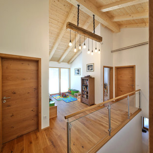 Mittelgroßer Moderner Flur mit weißer Wandfarbe, dunklem Holzboden und braunem Boden in München