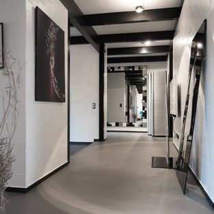 Großer Moderner Flur mit weißer Wandfarbe, Betonboden und grauem Boden in Köln