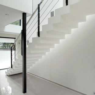 Idées déco pour un très grand couloir moderne avec un mur blanc, un sol en carrelage de porcelaine et un sol blanc.