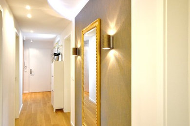 Imagen de recibidores y pasillos actuales de tamaño medio con suelo de madera en tonos medios, paredes blancas y iluminación