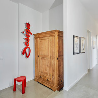 Mittelgroßer Moderner Flur mit weißer Wandfarbe, Betonboden und grauem Boden in Köln