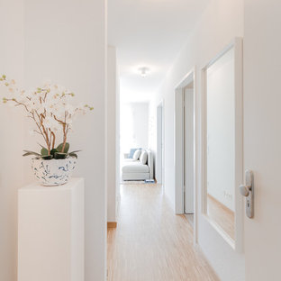 Réalisation d'un petit couloir nordique avec un mur blanc, un sol en bambou et un sol beige.