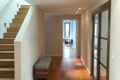 Diseño de recibidores y pasillos minimalistas de tamaño medio con paredes beige y suelo de madera clara