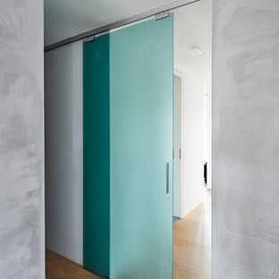 Immagine di un ingresso o corridoio minimalista di medie dimensioni con pareti grigie, pavimento in legno massello medio e pavimento marrone
