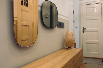Ejemplo de recibidores y pasillos contemporáneos de tamaño medio con paredes beige, suelo de madera clara y suelo beige