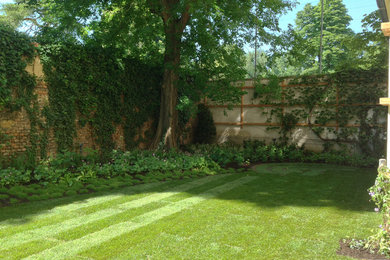 Inspiration för en liten vintage bakgård i delvis sol på sommaren, med en stödmur