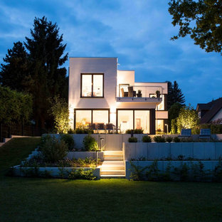 Mittelgroße Moderne Gartenmauer hinter dem Haus mit Betonplatten in Sonstige