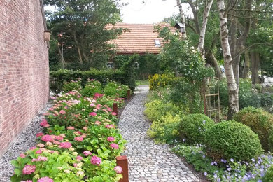 Foto de camino de jardín clásico de tamaño medio en patio delantero con adoquines de piedra natural