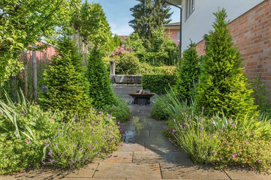Geometrischer, Mittelgroßer, Halbschattiger Landhausstil Gartenweg im Sommer, neben dem Haus mit Natursteinplatten in Sonstige