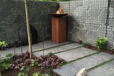 Mittelgroßer Moderner Garten hinter dem Haus mit Feuerstelle und Natursteinplatten in Essen