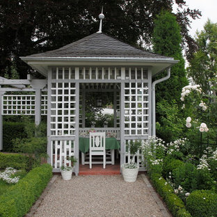 Immagine di un giardino tradizionale esposto a mezz'ombra davanti casa in estate con un ingresso o sentiero e ghiaia