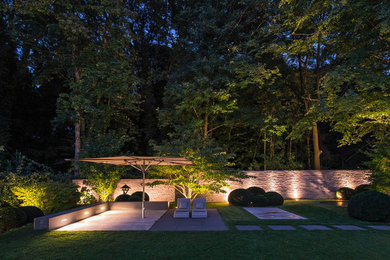 Inspiration for a contemporary garden wall in Cologne with a retaining wall and natural stone paving.