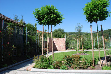 Mittelgroße, Halbschattige, Geometrische Moderne Gartenmauer im Sommer, hinter dem Haus mit Natursteinplatten in Frankfurt am Main