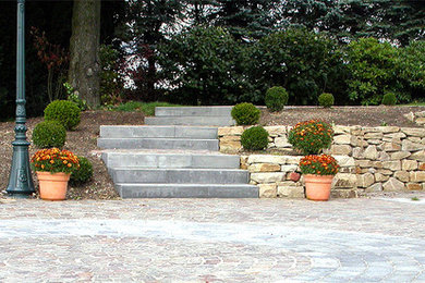 Design ideas for a large contemporary full sun garden in Dusseldorf with natural stone paving and a potted garden.