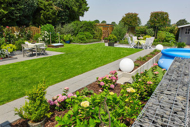 Cette image montre un aménagement d'entrée ou allée de jardin arrière design l'été avec une exposition ensoleillée et des pavés en pierre naturelle.