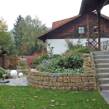 Gartenumgestaltung mit Teich und Natursteinmauer