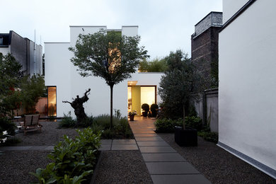 На фото: маленький участок и сад на переднем дворе в современном стиле с мощением тротуарной плиткой для на участке и в саду с