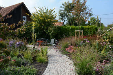 Mittelgroßer Country Gartenweg im Sommer, neben dem Haus mit direkter Sonneneinstrahlung und Natursteinplatten in Frankfurt am Main