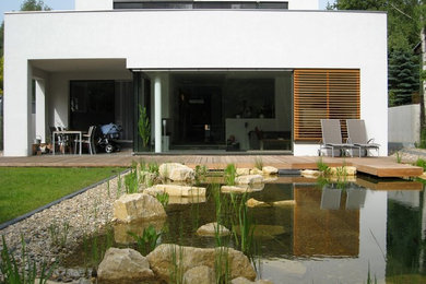Großer Moderner Garten hinter dem Haus mit Wasserspiel, direkter Sonneneinstrahlung und Dielen in Leipzig