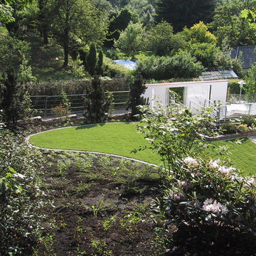 Hausgarten in Hanglage mit Natursteinmauern