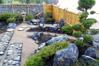 Modelo de jardín de estilo zen de tamaño medio en verano en patio con fuente y exposición parcial al sol