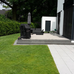 Mittelgroßer Moderner Gartenweg im Sommer, neben dem Haus mit direkter Sonneneinstrahlung und Betonplatten in Hamburg