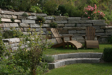 Modelo de jardín clásico de tamaño medio con muro de contención y adoquines de piedra natural