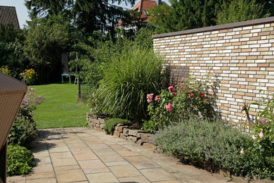 Ejemplo de camino de jardín actual en verano con adoquines de piedra natural