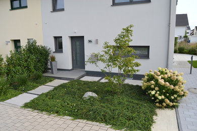 Halbschattiger Moderner Vorgarten im Sommer mit Betonboden in München