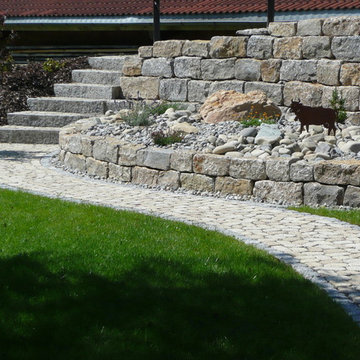 Weg mit Natursteinmauer und Stufen