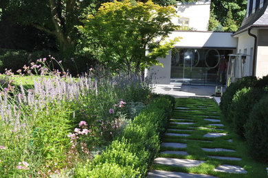 Exemple d'un grand aménagement d'entrée ou allée de jardin chic avec une exposition ombragée et des pavés en pierre naturelle.
