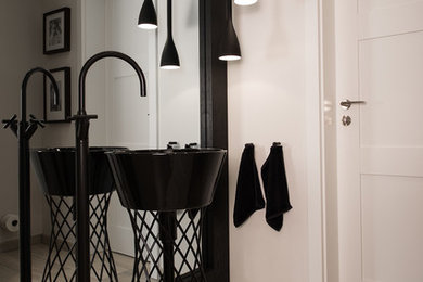 Foto di un bagno di servizio design di medie dimensioni con pareti bianche, lavabo a colonna e parquet chiaro