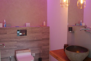 Bild på ett mellanstort funkis toalett, med ett fristående handfat, en vägghängd toalettstol, beige väggar och vinylgolv