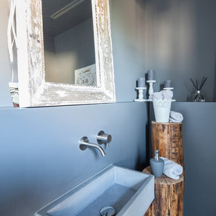 Esempio di un bagno di servizio stile shabby di medie dimensioni con pareti grigie, lavabo sospeso, top in cemento, nessun'anta, ante bianche, WC sospeso, piastrelle blu, parquet chiaro e pavimento marrone