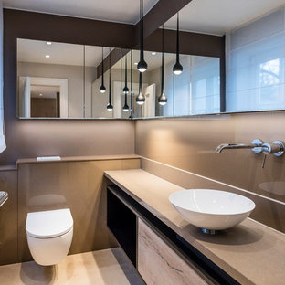 Moderne Gästetoilette mit flächenbündigen Schrankfronten, hellen Holzschränken, Wandtoilette, beigefarbenen Fliesen, brauner Wandfarbe, Aufsatzwaschbecken, beigem Boden und beiger Waschtischplatte in Frankfurt am Main
