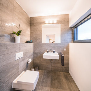 Kleine Moderne Gästetoilette mit Wandtoilette mit Spülkasten, beigefarbenen Fliesen, braunen Fliesen, weißer Wandfarbe, Wandwaschbecken und beigem Boden in Frankfurt am Main