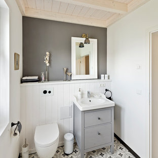 Esempio di un piccolo bagno di servizio country con ante lisce, ante grigie, WC sospeso, pavimento in gres porcellanato, lavabo a bacinella, top in legno, pavimento grigio e pareti grigie